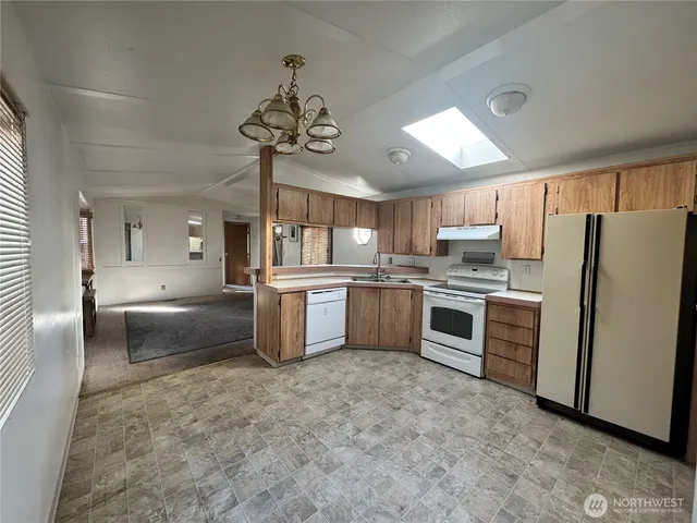 a large kitchen with cabinets wooden floor and stainless steel appliances