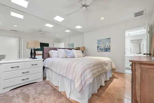 a large bedroom with a bed and a chandelier