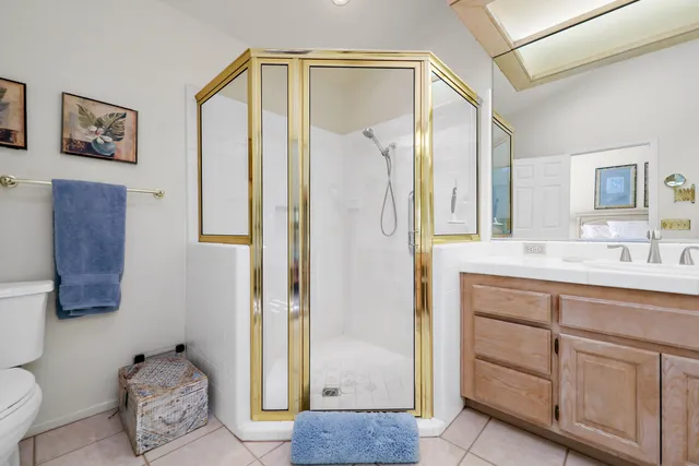 a en suite bathroom with a shower sink and mirror