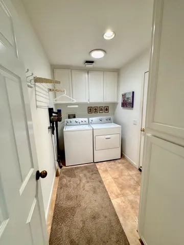 a utility room with cabinets washer and dryer