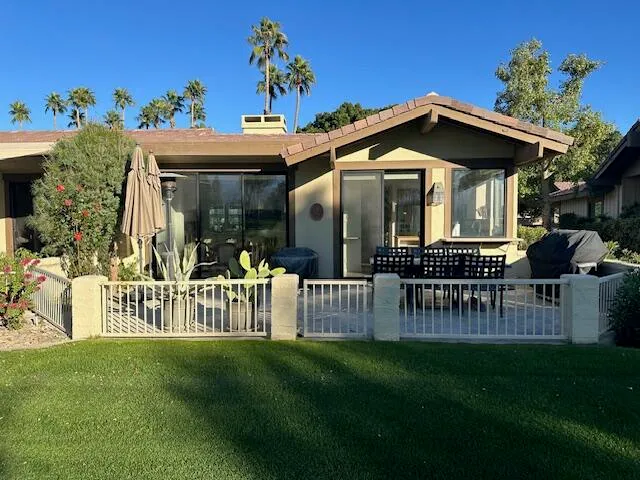 a view of a house with a small yard and a bench