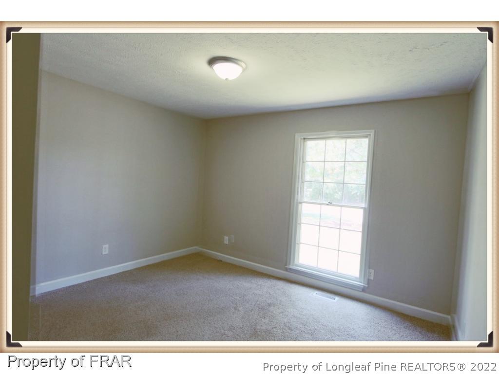 7786 Dragonhead Road Fayetteville, NC 28311 - Photo 19 of 33 an empty room with wooden floor and windows