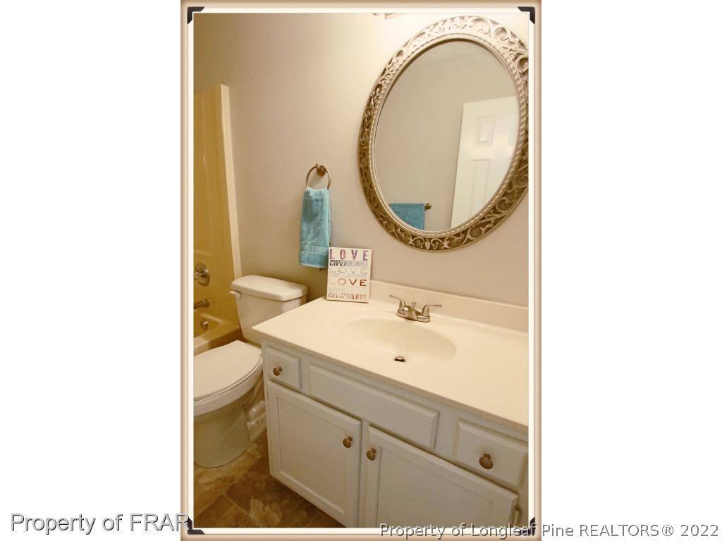 7786 Dragonhead Road Fayetteville, NC 28311 - Photo 21 of 33 a bathroom with a sink a mirror and a toilet
