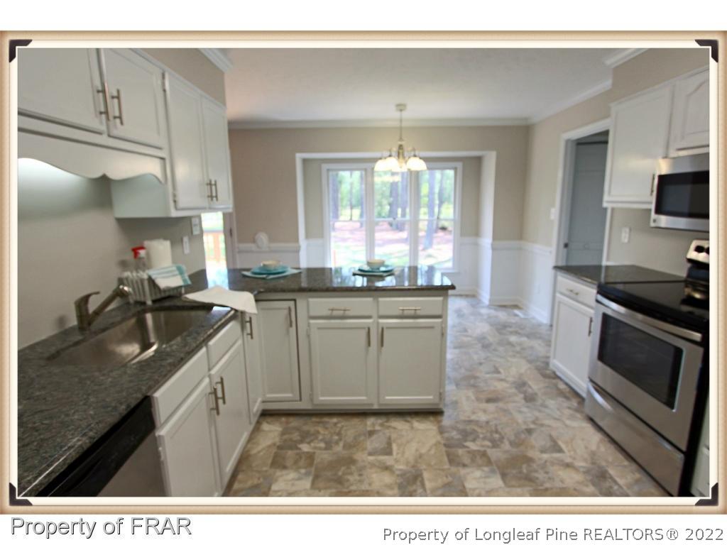 7786 Dragonhead Road Fayetteville, NC 28311 - Photo 6 of 33 a kitchen with a sink stove and microwave