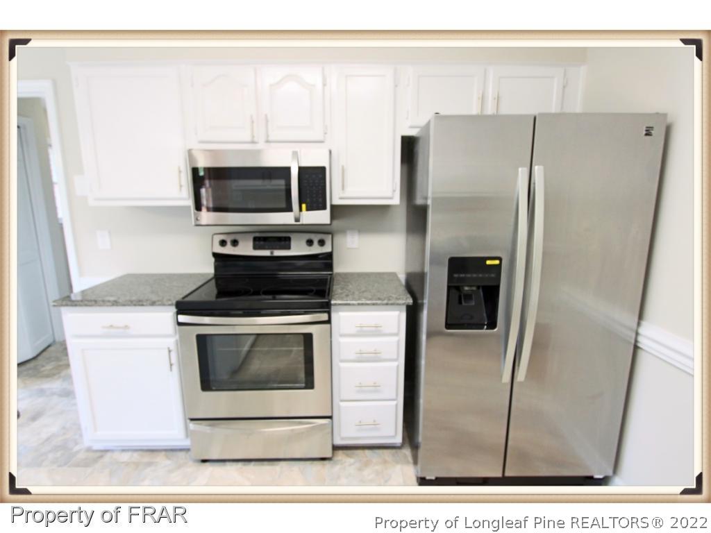 7786 Dragonhead Road Fayetteville, NC 28311 - Photo 8 of 33 a kitchen with stainless steel appliances a refrigerator a stove a microwave and sink