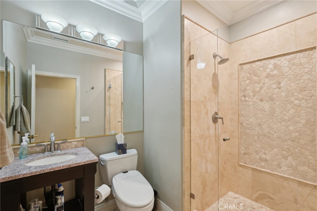 5965 Vía Loma Riverside, CA 92506 - Photo 26 of 41 a bathroom with a granite countertop toilet a sink and a mirror