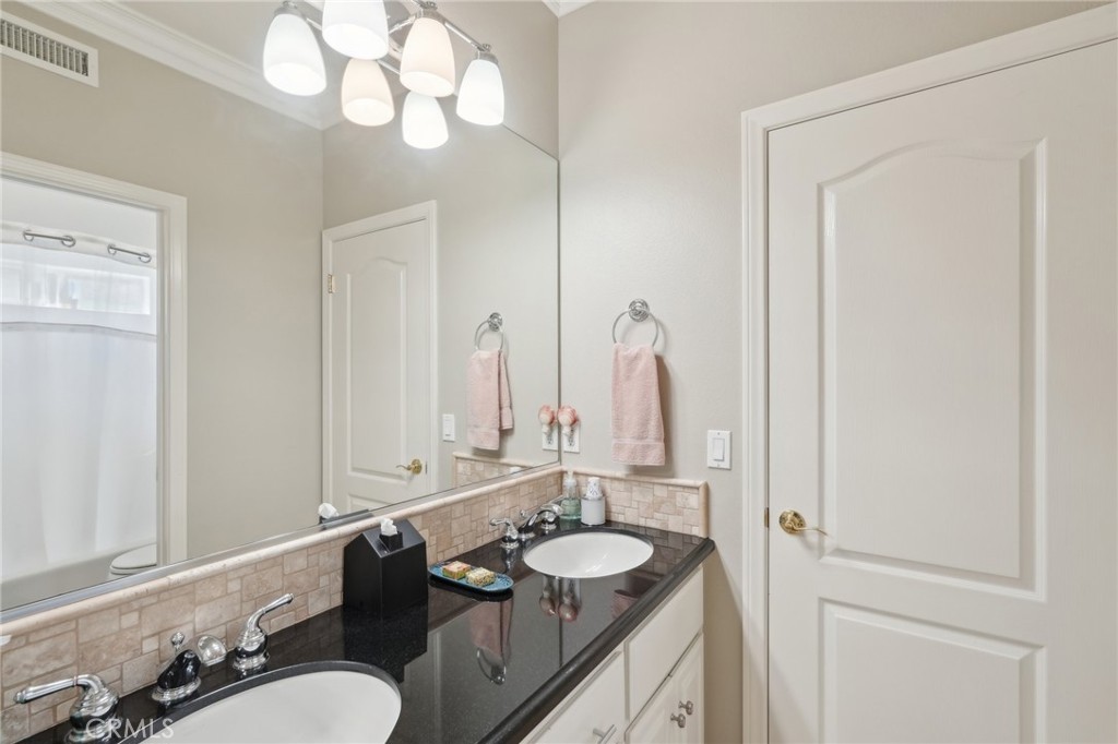 5965 Vía Loma Riverside, CA 92506 - Photo 30 of 41 a bathroom with a double vanity sink and a mirror