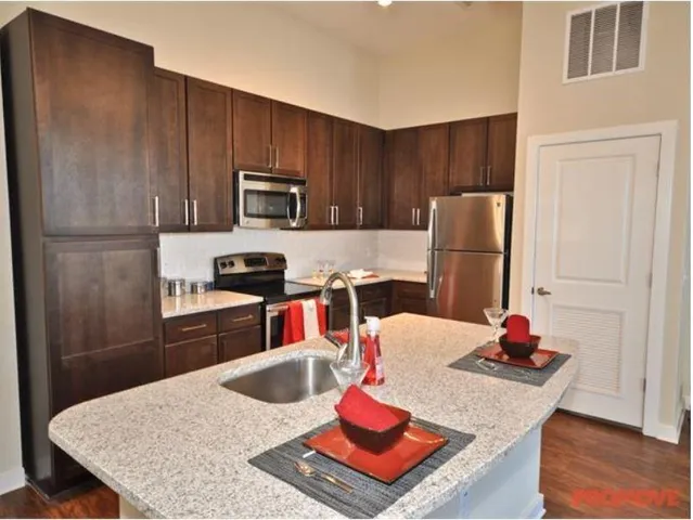 a kitchen with a refrigerator a stove and a dining table