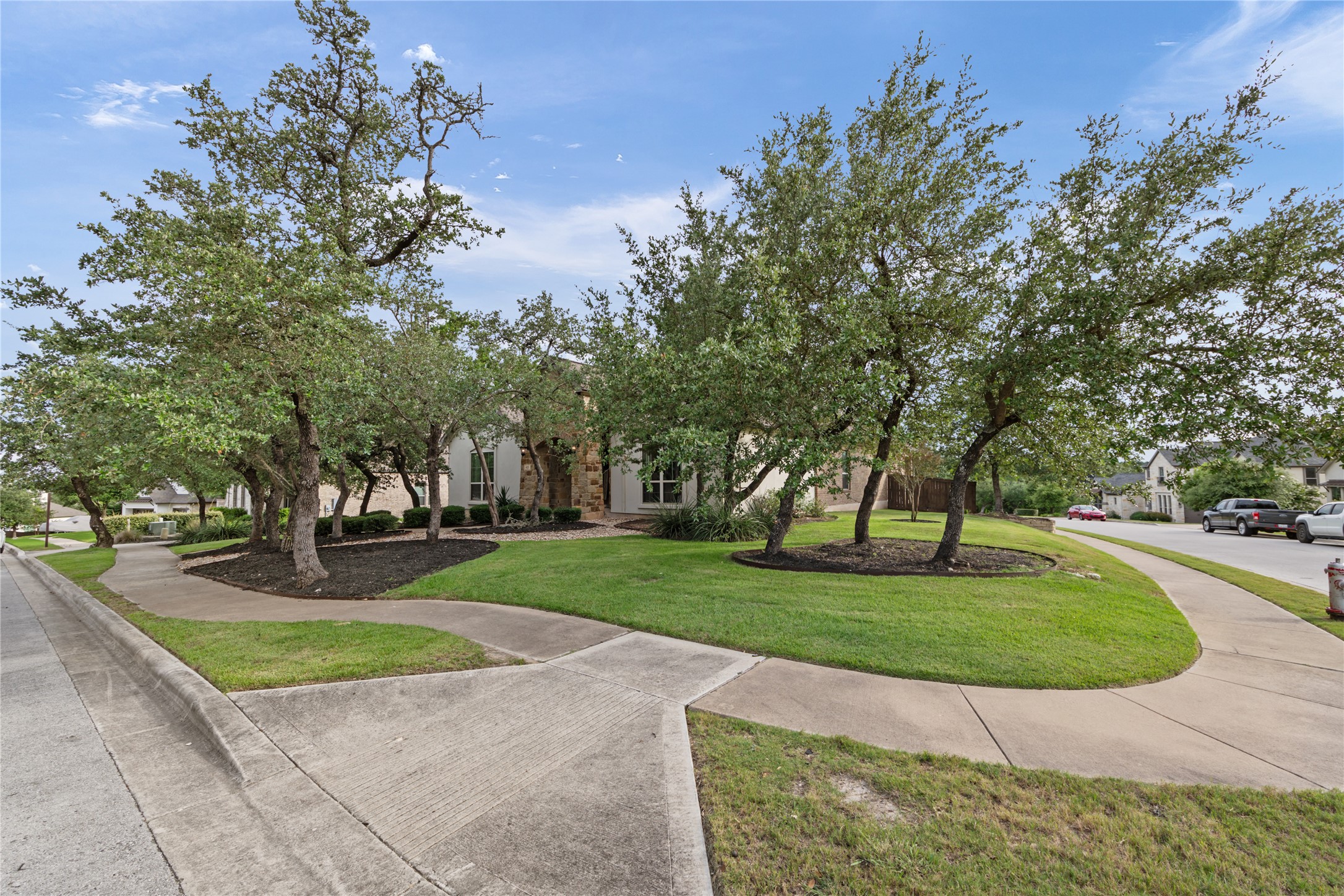 415 Bitterroot Lane Austin, TX 78737 - Photo 2 of 25 Mature trees frame the welcoming entrance of this property, enhancing its inviting curb appeal.