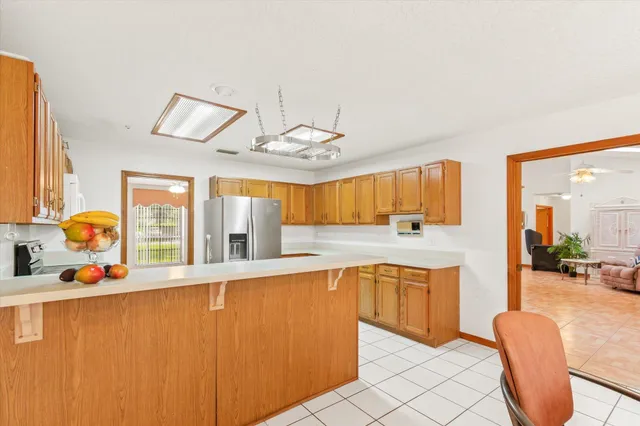 a view of an empty room with chandelier fan