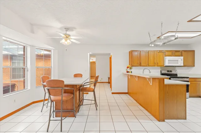 a kitchen with stainless steel appliances granite countertop a sink and a stove top oven with wooden floor