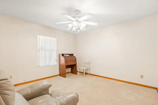 a view of an empty room and chandelier fan