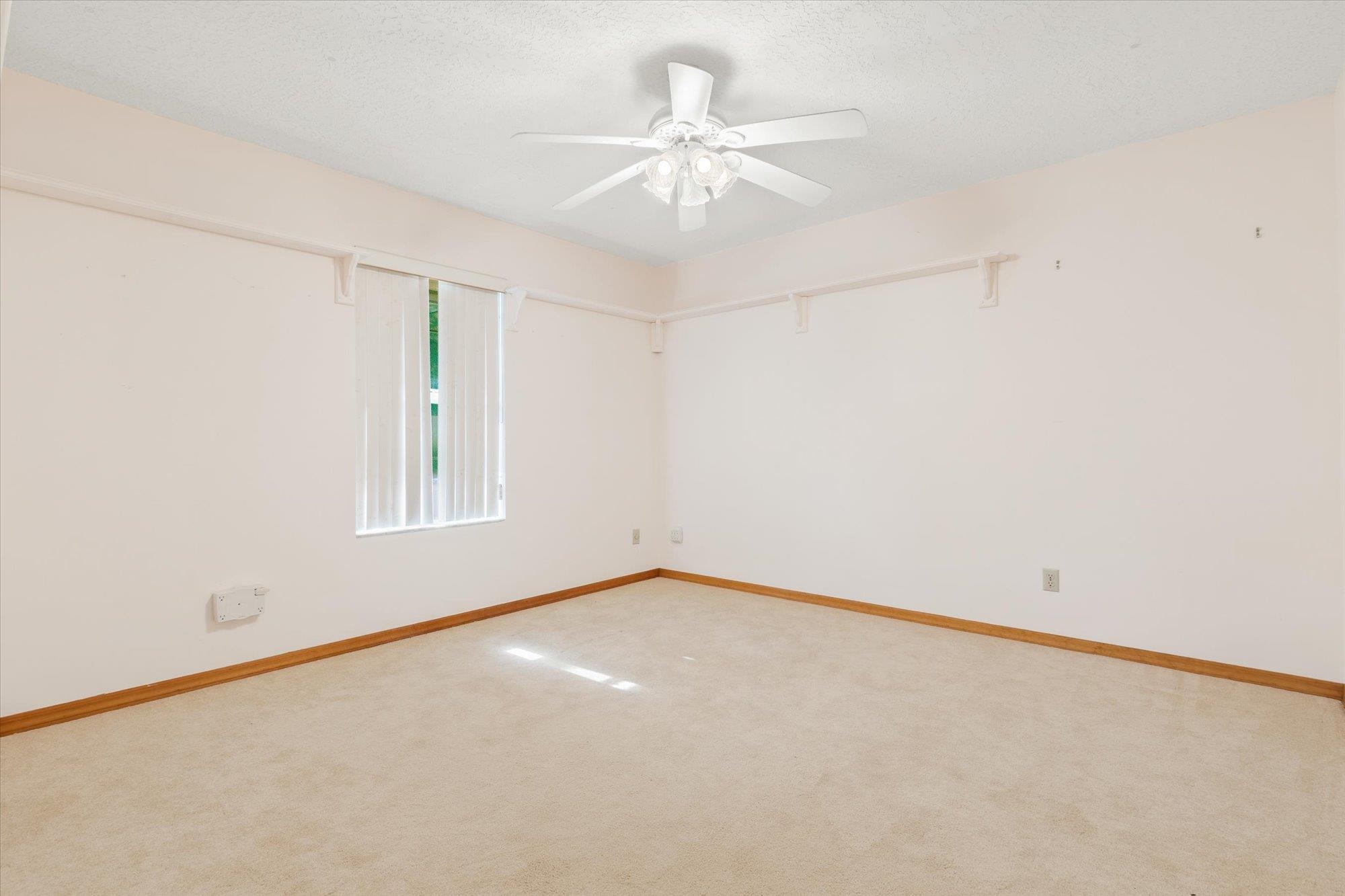 913 Chippewa Street St. Augustine, FL 32086 - Photo 35 of 56 an empty room with a chandelier fan and windows