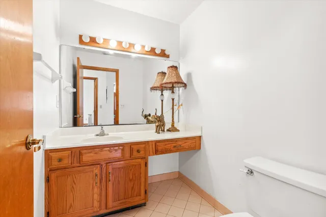 a kitchen with stainless steel appliances kitchen island granite countertop a refrigerator a sink dishwasher a dining table and chairs with wooden floor