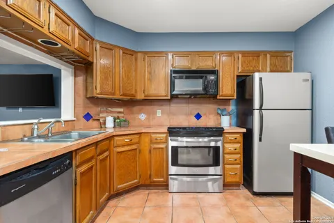 a kitchen with stainless steel appliances granite countertop a refrigerator stove microwave and sink