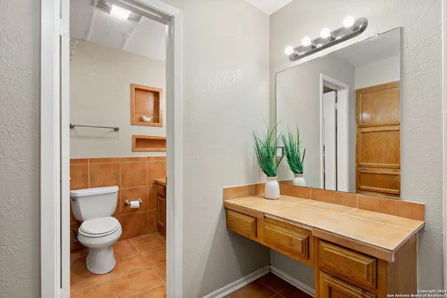 a bathroom with a toilet a sink and mirror
