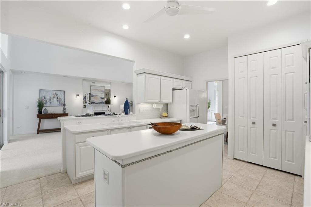 1737 Marsh Run Naples, FL 34109 - Photo 12 of 45 a kitchen that has a sink and a stove with white cabinets