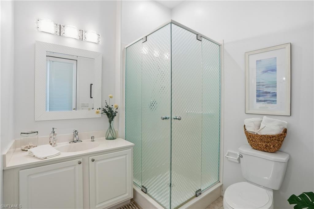 1737 Marsh Run Naples, FL 34109 - Photo 14 of 45 a bathroom with a toilet a sink a mirror a vanity and shower