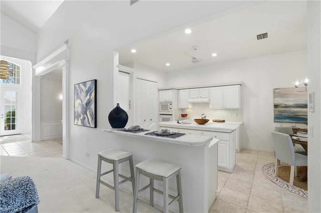 1737 Marsh Run Naples, FL 34109 - Photo 9 of 45 a kitchen with stainless steel appliances granite countertop a sink and a refrigerator