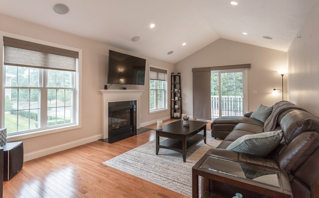 22 Highland Road, Unit 31 Raynham, MA 02767 - Photo 2 of 28 a living room with furniture a flat screen tv and a fireplace
