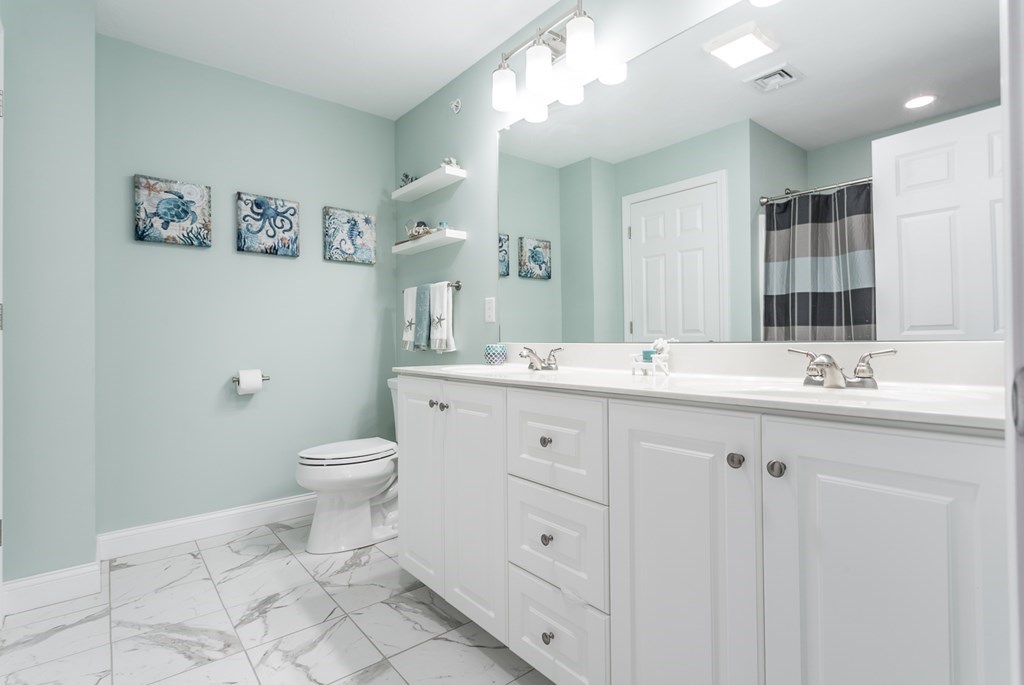 22 Highland Road, Unit 31 Raynham, MA 02767 - Photo 23 of 28 a bathroom with 2 sink toilet and a mirror