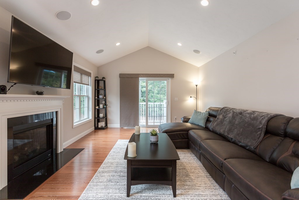 22 Highland Road, Unit 31 Raynham, MA 02767 - Photo 3 of 28 a living room with furniture a flat screen tv and a fireplace