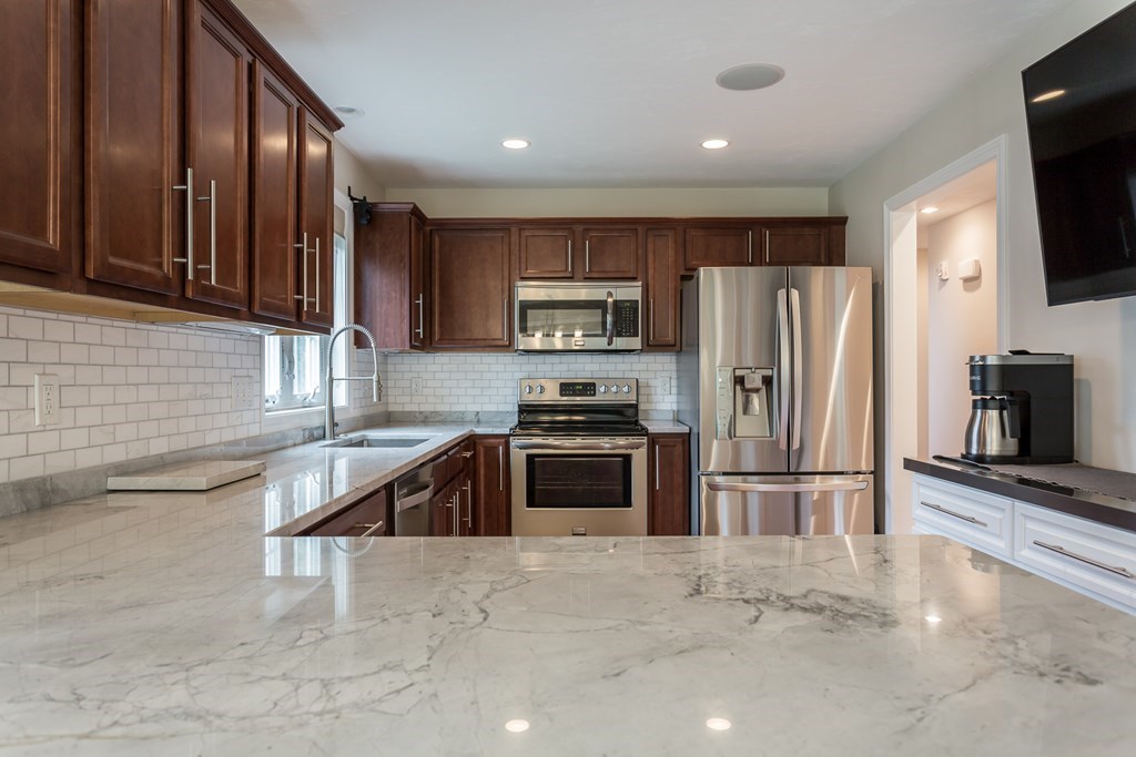 22 Highland Road, Unit 31 Raynham, MA 02767 - Photo 8 of 28 a kitchen with granite countertop a refrigerator and a sink