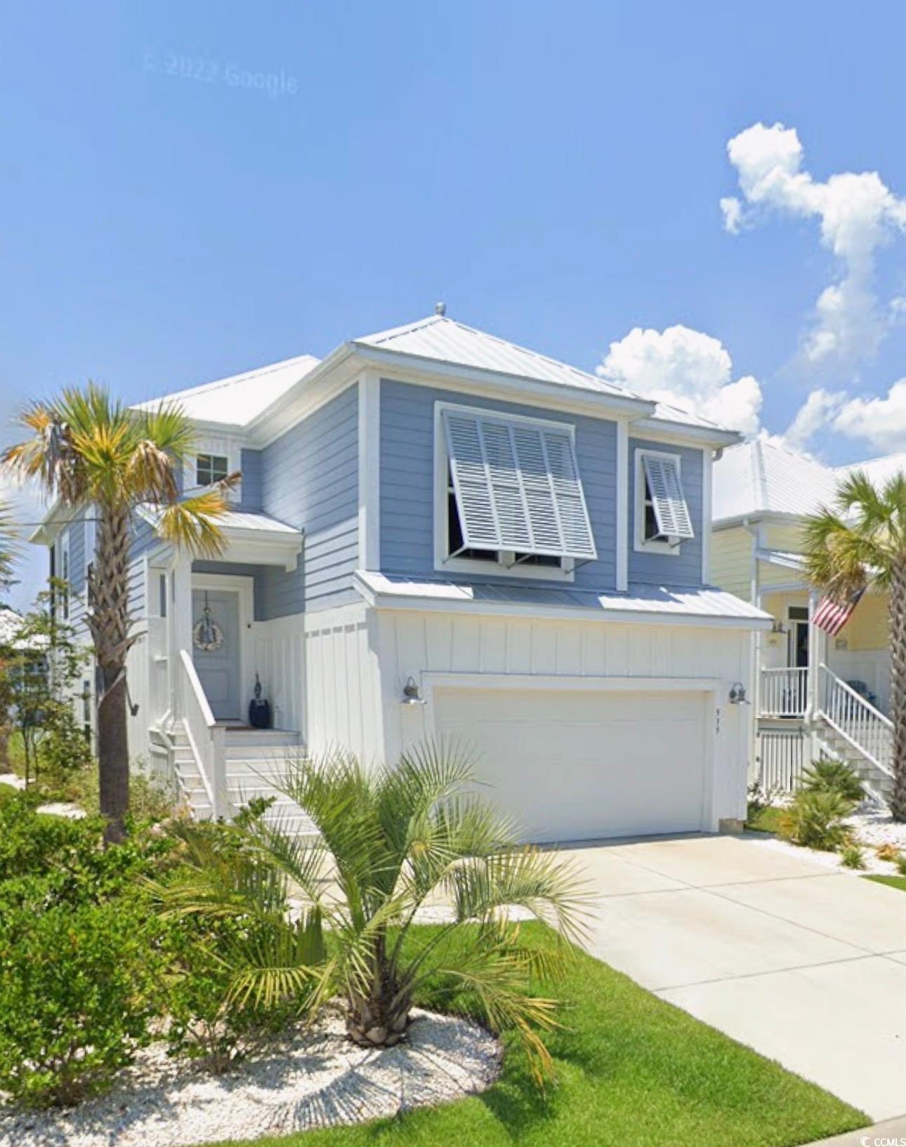 View of property exterior featuring an attached garage, concrete driveway, board and batten siding, and stairs