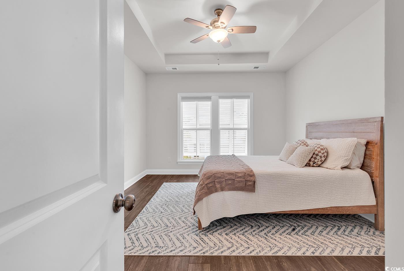 535 Chanted Drive Murrells Inlet, SC 29576 - Photo 13 of 37 Bedroom featuring wood finished floors, a tray ceiling, and a ceiling fan