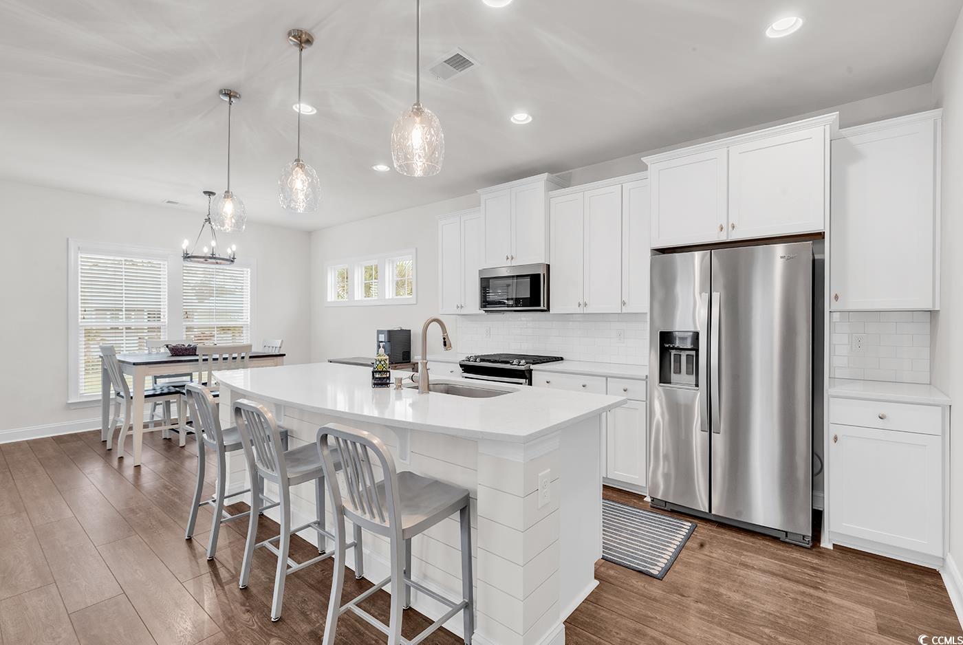 535 Chanted Drive Murrells Inlet, SC 29576 - Photo 7 of 37 Kitchen featuring stainless steel appliances, an island with sink, recessed lighting, white cabinetry, and a breakfast bar area