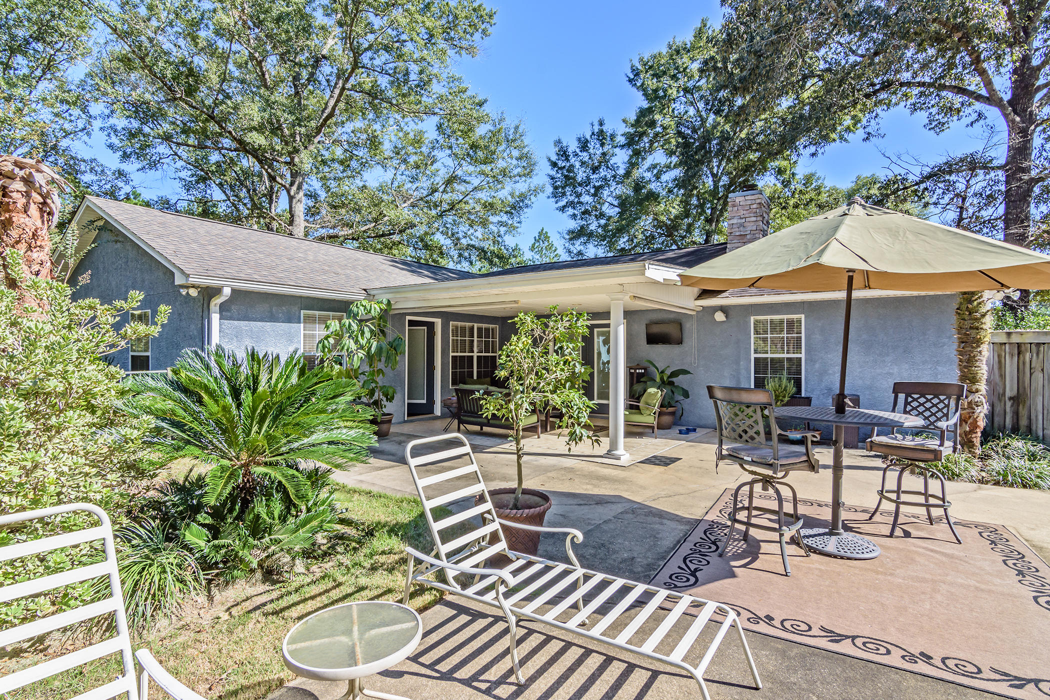 7262 Old River Road Baker, FL 32531 - Photo 27 of 63 a view of a patio with table and chairs potted plants and a large tree