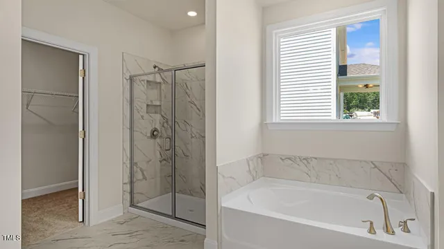 a white bath tub sitting next to a shower