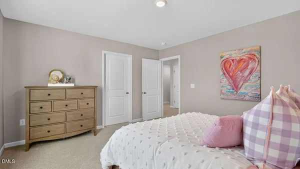 a bedroom with a bed and a dresser in it