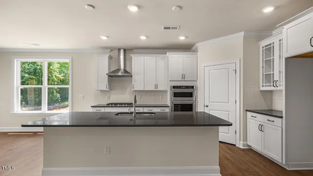 a kitchen with stainless steel appliances granite countertop a refrigerator sink and stove