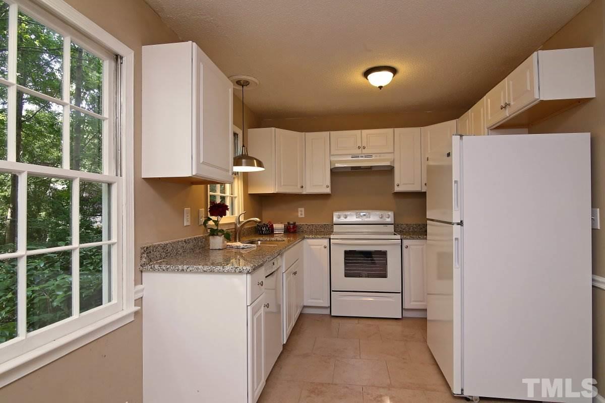 7700 Greentree Court Raleigh, NC 27615 - Photo 11 of 25 a kitchen with kitchen island a stove a sink and a refrigerator