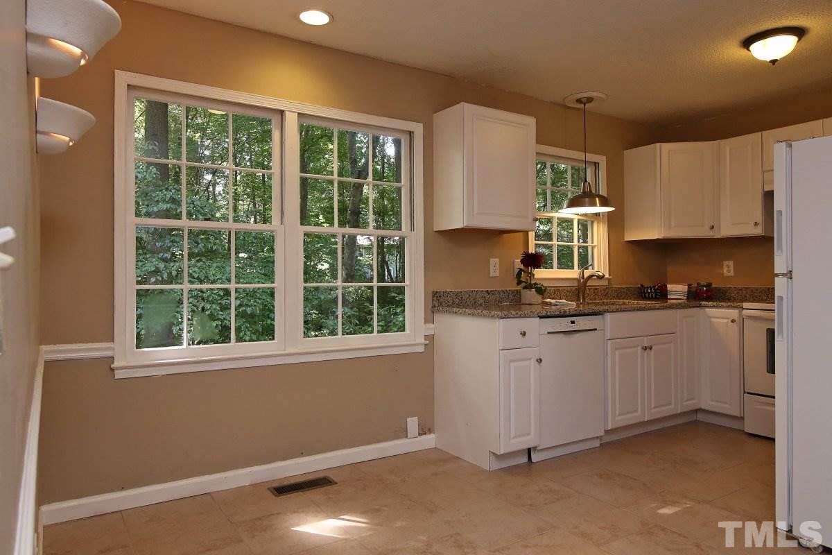 7700 Greentree Court Raleigh, NC 27615 - Photo 14 of 25 a kitchen with granite countertop a stove a sink and a granite counter top