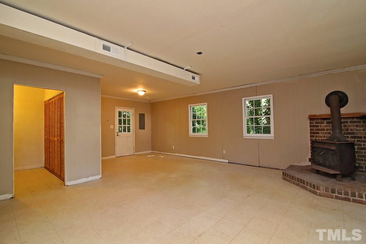 7700 Greentree Court Raleigh, NC 27615 - Photo 22 of 25 a view of an empty room with a fireplace and a window