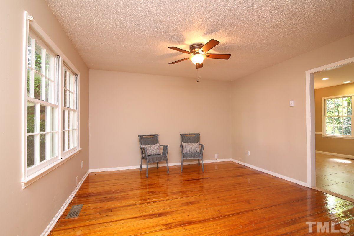 7700 Greentree Court Raleigh, NC 27615 - Photo 9 of 25 a view of a room with wooden floor a ceiling fan and windows