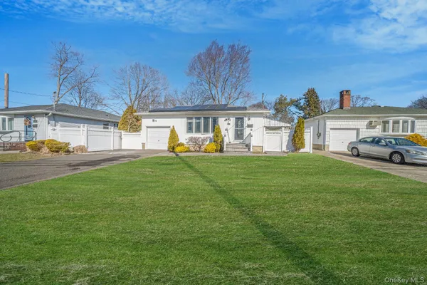 a view of a house with a big yard and large trees