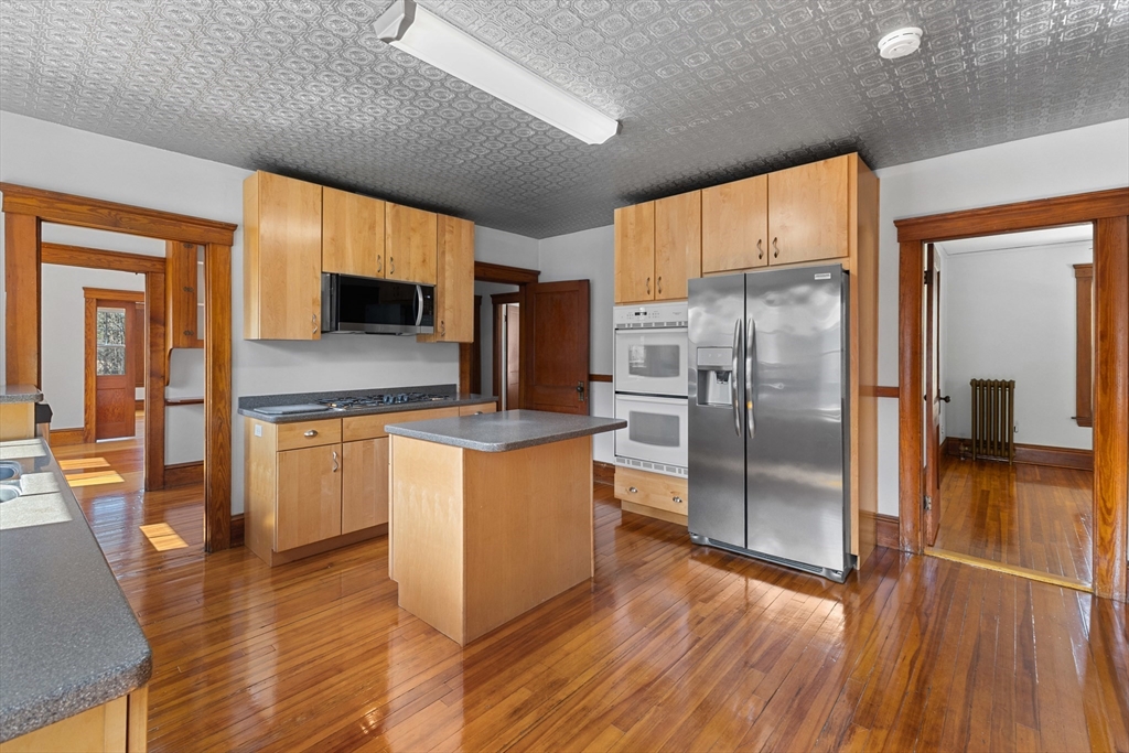 183 Pleasant Street, Unit 2 Grafton, MA 01560 - Photo 1 of 34 a kitchen with granite countertop a refrigerator and a stove top oven