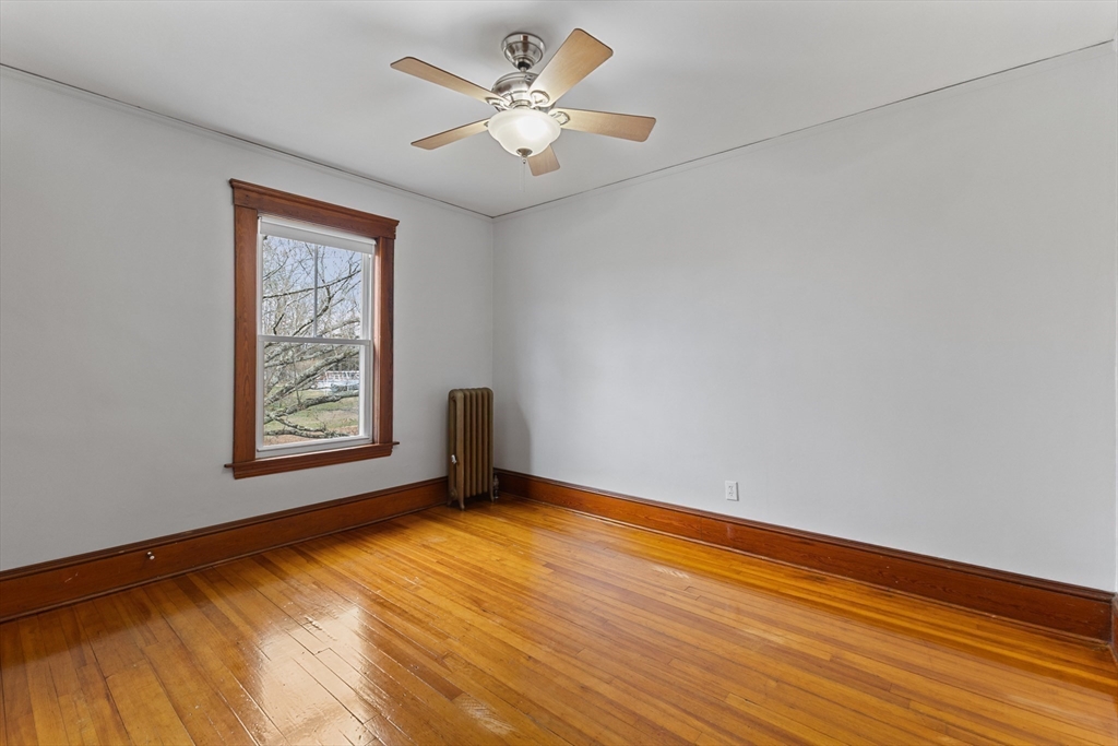 183 Pleasant Street, Unit 2 Grafton, MA 01560 - Photo 15 of 34 a view of an empty room with a window and wooden floor