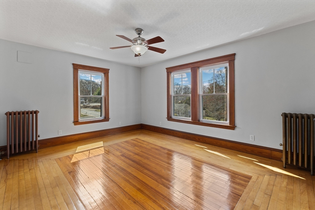 183 Pleasant Street, Unit 2 Grafton, MA 01560 - Photo 16 of 34 a view of an empty room with window and wooden floor