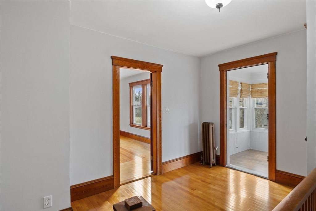 183 Pleasant Street, Unit 2 Grafton, MA 01560 - Photo 17 of 34 a view of a hallway with wooden floor and a livingroom