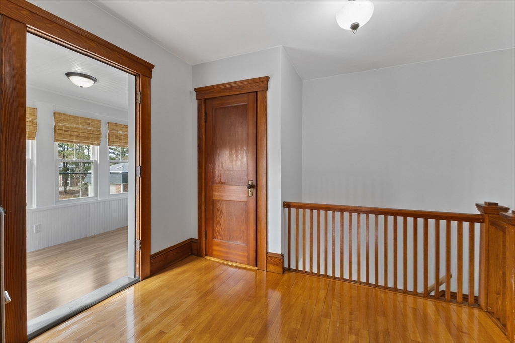 183 Pleasant Street, Unit 2 Grafton, MA 01560 - Photo 20 of 34 a view of a hallway with wooden floor and a bathroom