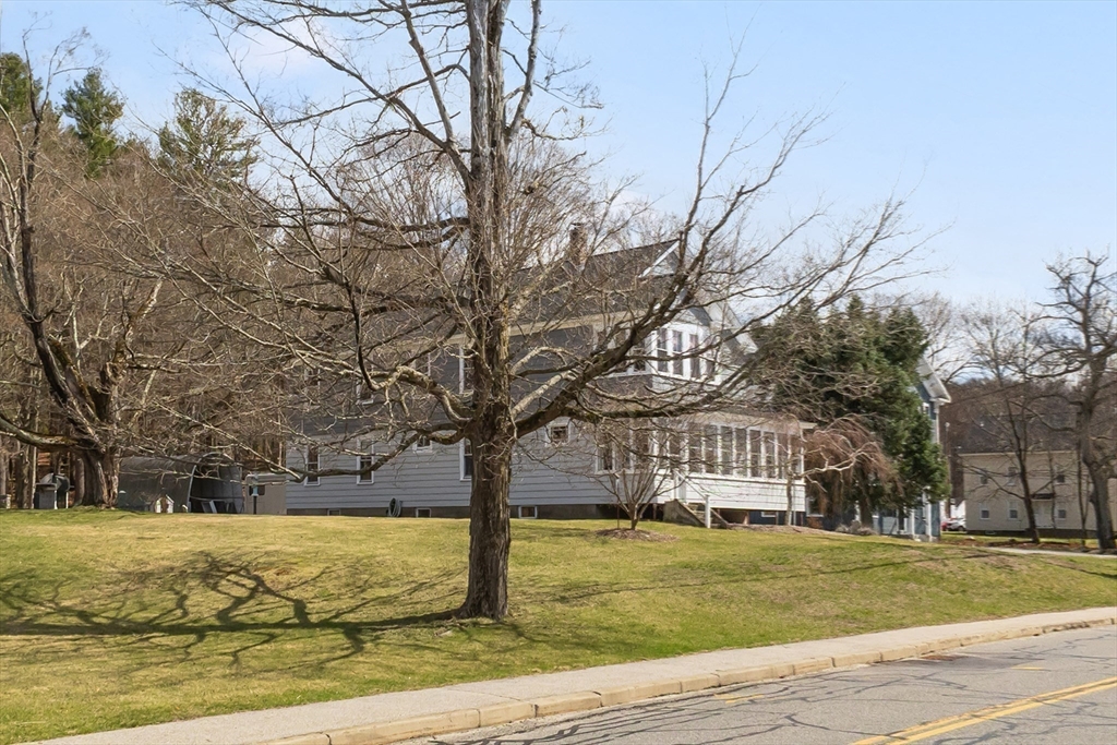 183 Pleasant Street, Unit 2 Grafton, MA 01560 - Photo 26 of 34 a view of yard with large tree and wooden fence