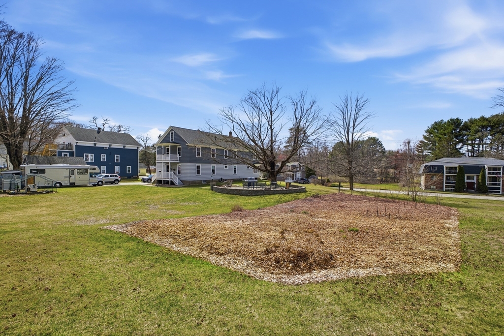 183 Pleasant Street, Unit 2 Grafton, MA 01560 - Photo 33 of 34 a view of yard with swimming pool and trees in the background
