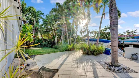 a kitchen with stainless steel appliances kitchen island granite countertop a refrigerator a stove a sink a dining table and chairs with wooden floor