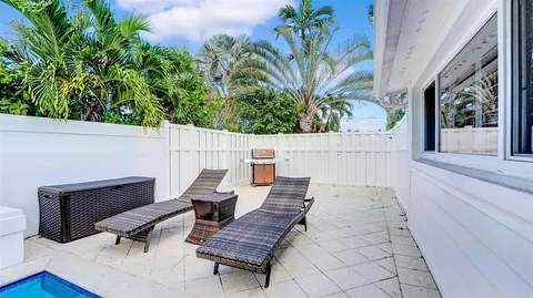 a kitchen with kitchen island stainless steel appliances a dining table chairs and sink