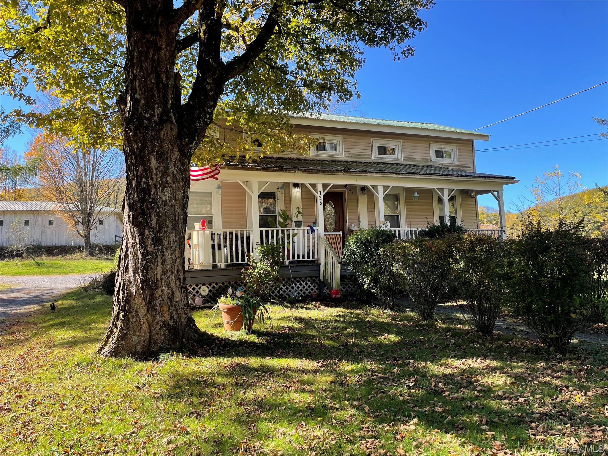 a view of a white house with a large pool and large trees