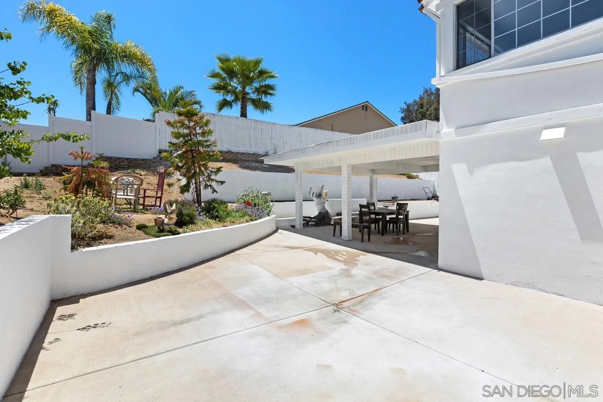 13749 Avenida Del Charro El Cajon, CA 92021 - Photo 24 of 24 a view of a patio with table and chairs potted plants and palm tree